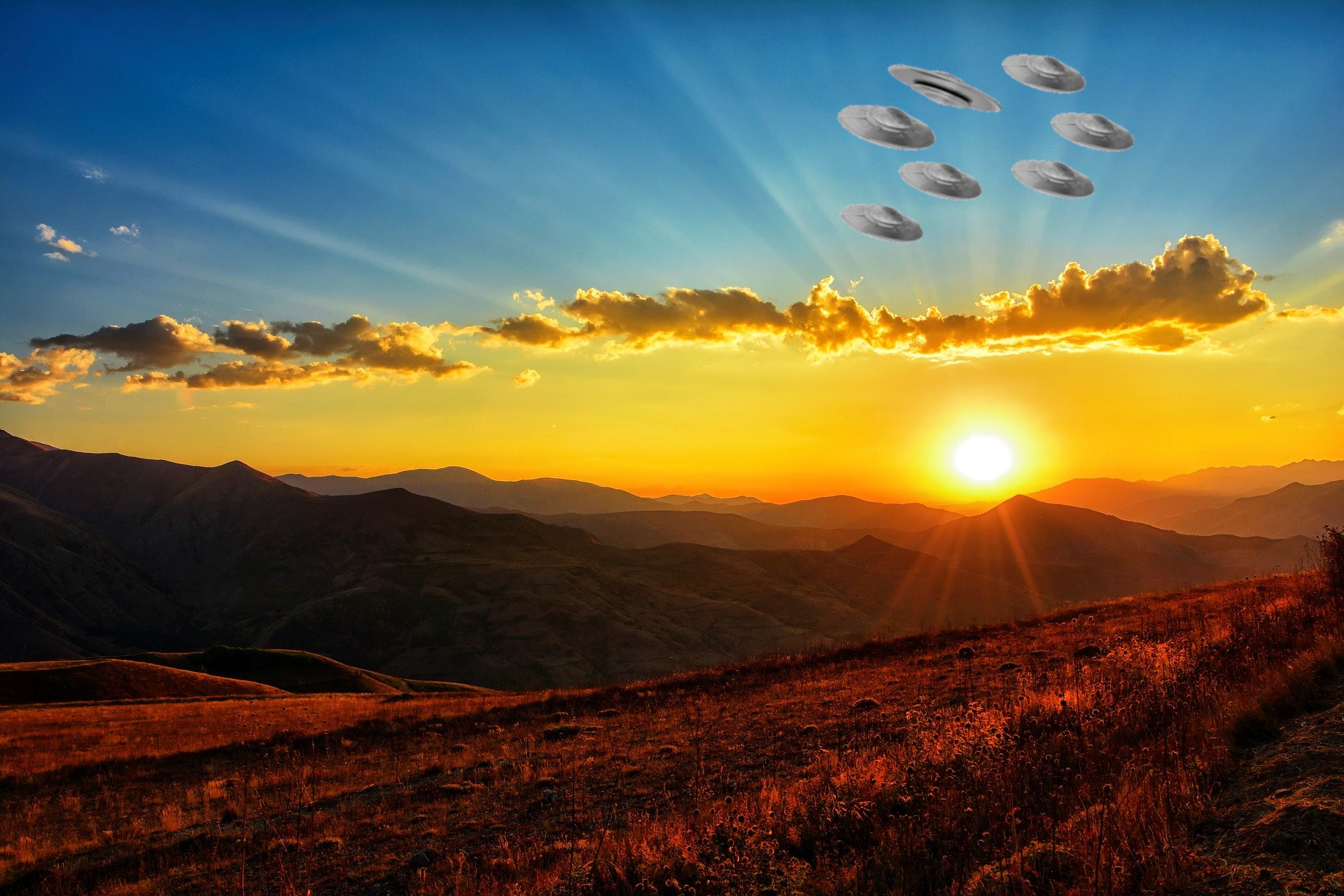 A depiction of several UFOs flying over a field