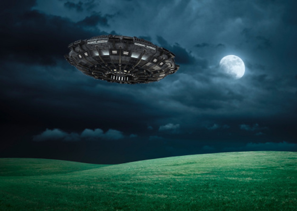 A depiction of a UFO over a field