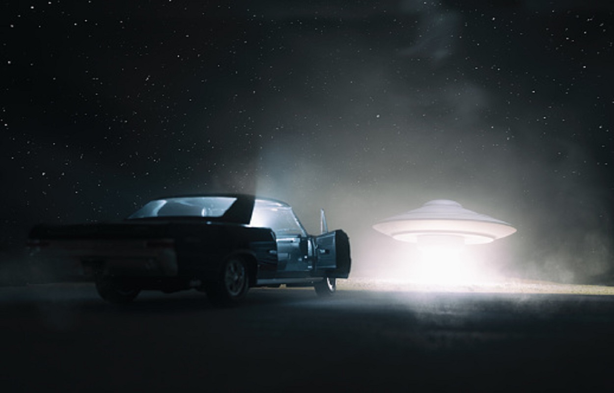 A depiction of a UFO in front of a car